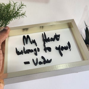 Op de afbeelding: Een ingelijst bericht in een gouden lijst met de tekst "My heart belongs to you! - Vada" geschreven in zwarte 3D-letters.