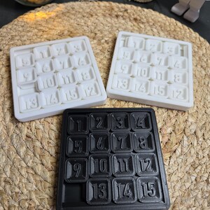 May include: Three 15-piece number puzzles, one black and two white. Each puzzle has numbers 1 through 15 arranged in a 4x4 grid.