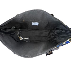 Puede incluir: El interior de una bolsa de mano negra con un forro estampado en azul y dorado. La bolsa tiene un cierre de cremallera y un peque&ntilde;o bolsillo en el interior. La etiqueta en el interior de la bolsa dice "Willow & Blake, Designed in New York."