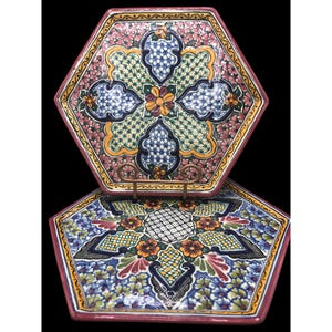 May include: Two hexagonal ceramic plates with intricate floral designs in shades of pink, blue, green, yellow, and orange. The plates are stacked on top of each other.