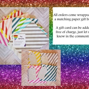 Puede incluir: Un conjunto de bolsas de regalo a rayas de colores con etiquetas de regalo a juego. Las bolsas son de papel y tienen una variedad de colores y patrones. Las etiquetas son de papel de purpurina y tienen una cuerda blanca atada. El texto en la tarjeta de visita dice "Toy Worlwind". Todos los pedidos vienen envueltos en una bolsa de regalo de papel a juego. Se puede agregar una tarjeta de regalo sin cargo, solo h&aacute;znoslo saber en los comentarios.