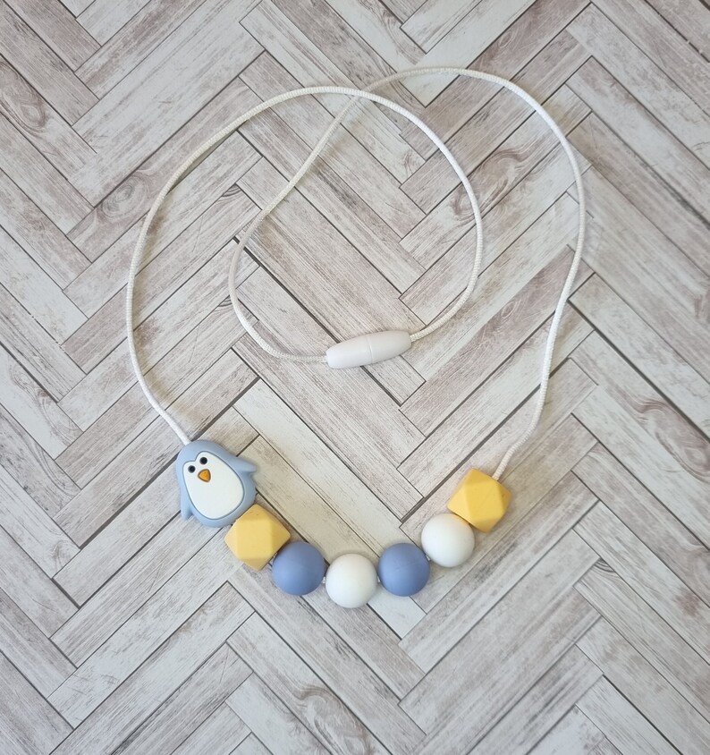 Puede incluir: Un collar de dentici&oacute;n de silicona azul y amarillo con un dije de ping&uuml;ino. El collar est&aacute; hecho de cuentas de silicona suaves y masticables y est&aacute; dise&ntilde;ado para beb&eacute;s y ni&ntilde;os peque&ntilde;os.