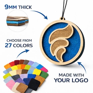 以下が含まれることがあります： ロゴデザインの丸い木製オーナメント、厚さ9mm、青色の内側と天然木の外側が特徴です。画像には27色のカラーパレットと「MADE WITH YOUR LOGO」というテキストが含まれています。