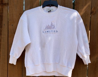 May include: White sweatshirt with a blue and purple graphic of trees and the text "LIMITED winter landscape".