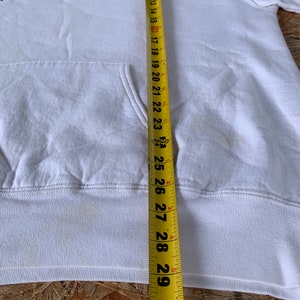 May include: White hoodie with a black Nike logo and the word "AIR" in white lettering. The hoodie is measured with a tape measure, showing a length of 29 inches.