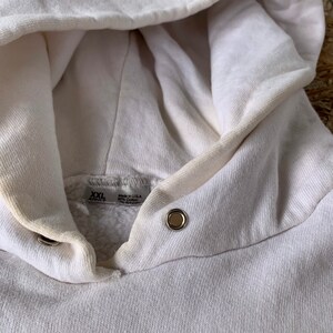 May include: White hooded sweatshirt with a tag that reads "XXL" and "Made in USA 80% Cotton 20% Polyester".