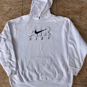 May include: White hooded sweatshirt with a black Nike logo and the word "AIR" in a stylized font.