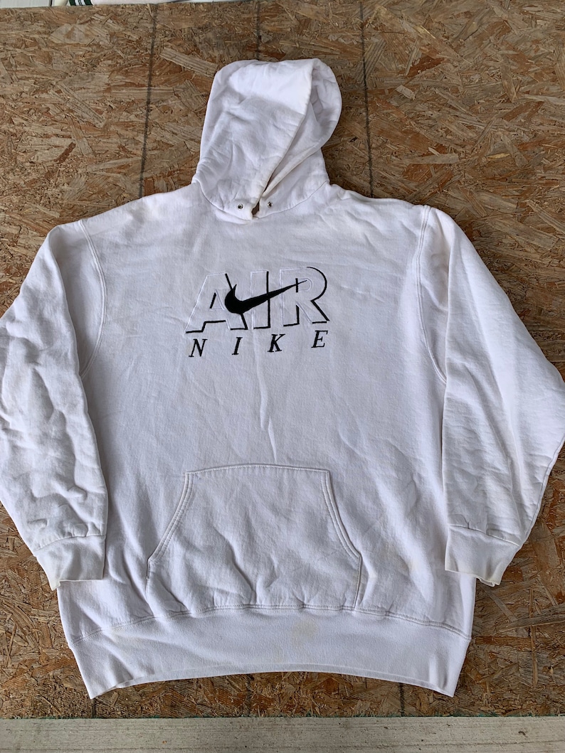 May include: White hooded sweatshirt with a black Nike logo and the word "AIR" in a stylized font.