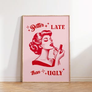 Pu&ograve; includere: Un poster rosa e rosso con una donna che si mette il rossetto. Il testo dice "Meglio tardi che mai".