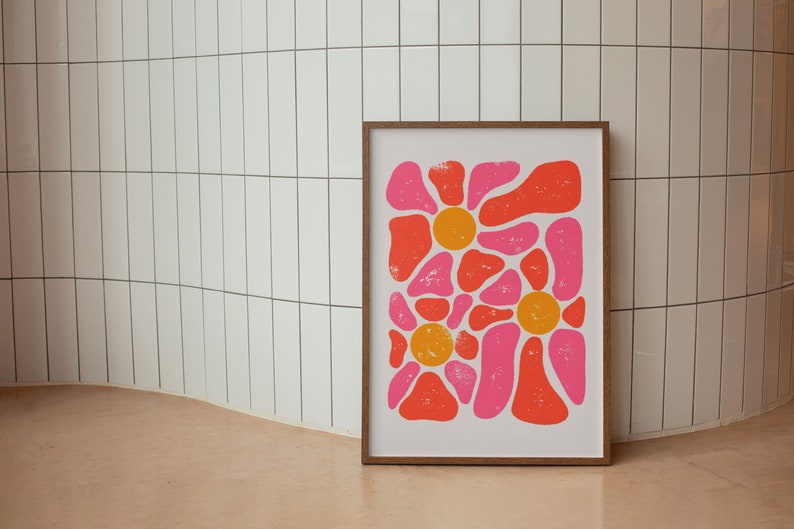 May include: A framed print of an abstract floral design with pink and orange shapes. The print is on a white background and has a distressed look.