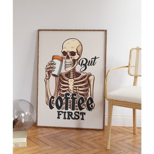 May include: A skeleton holding a cup of coffee with the text "But coffee first" in black lettering.