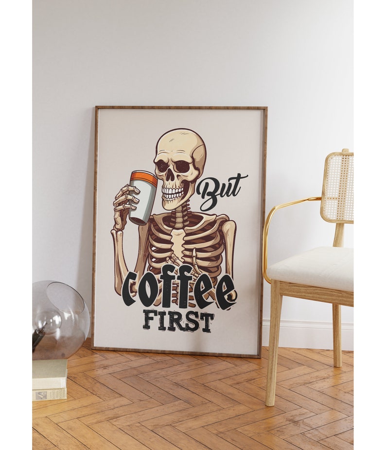 May include: A skeleton holding a cup of coffee with the text "But coffee first" in black lettering.