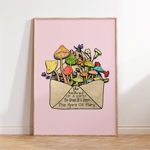 May include: A framed art print featuring a pink background and a whimsical illustration. The artwork depicts colorful mushrooms and flowers emerging from a tan envelope. Text on the envelope reads: "she has the soul of a gypsy, the heart of a hippie, the spirit of a fairy."