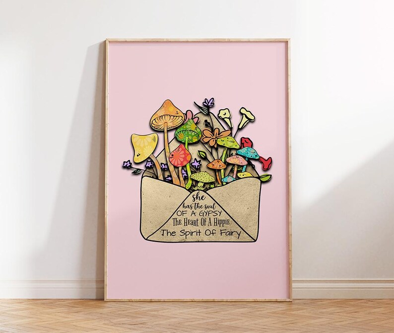 May include: A framed art print featuring a pink background and a whimsical illustration. The artwork depicts colorful mushrooms and flowers emerging from a tan envelope. Text on the envelope reads: "she has the soul of a gypsy, the heart of a hippie, the spirit of a fairy."