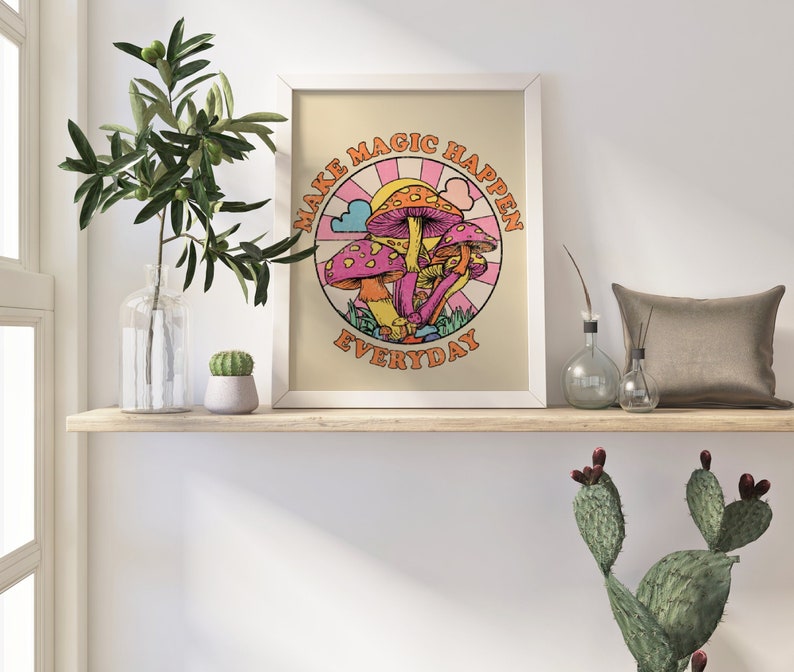 May include: A white framed print with a colorful illustration of mushrooms and the text "Make Magic Happen Everyday".
