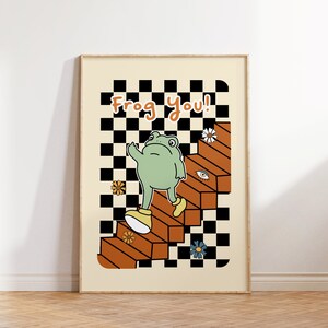 May include: A green frog wearing yellow shoes walks up a set of orange stairs with a black and white chequered background. The text "Frog you!" is written in orange letters at the top of the image.