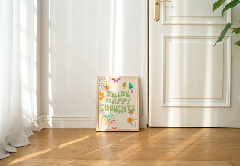 May include: A framed print with a white background and green text that reads "Think Happy Thoughts". The print is decorated with colorful flowers, smiley faces, and mushrooms.
