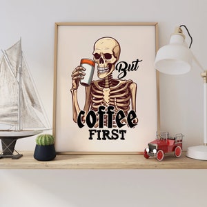 May include: A skeleton holding a cup of coffee with the text "But coffee first" printed below. The skeleton is wearing a white shirt and has a black outline.