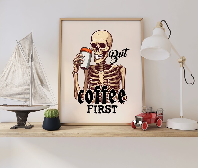 May include: A skeleton holding a cup of coffee with the text "But coffee first" printed below. The skeleton is wearing a white shirt and has a black outline.