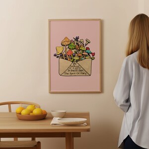 May include: A framed art print featuring a whimsical illustration of colorful mushrooms and flowers emerging from an envelope. The artwork is set against a pink background, with text that reads "she has the soul of a gypsy, the heart of a hippie, the spirit of fairy."