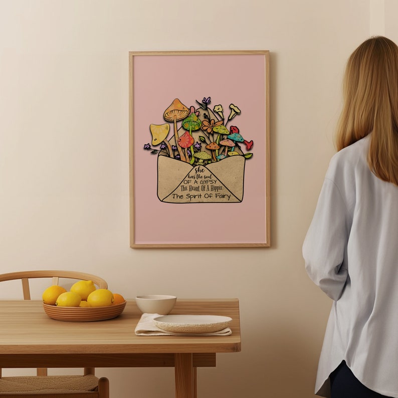 May include: A framed art print featuring a whimsical illustration of colorful mushrooms and flowers emerging from an envelope. The artwork is set against a pink background, with text that reads "she has the soul of a gypsy, the heart of a hippie, the spirit of fairy."