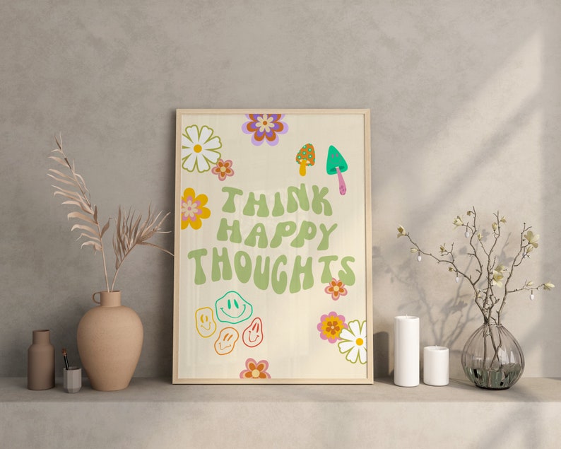 May include: A framed print with a white background and green text that reads "Think Happy Thoughts". The print is decorated with colorful flowers, mushrooms, and smiley faces.