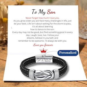 May include: A black leather bracelet with a silver knot design and a silver clasp engraved with "Love you forever". The bracelet is on a card with a message to a son.