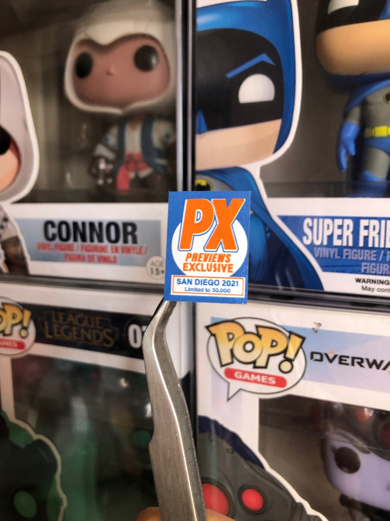 May include: A blue and orange sticker with the text "PX Previews Exclusive" and "San Diego 2021 Limited to 30,000".