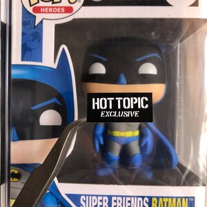 May include: A blue and black Batman Funko Pop! vinyl figure with a yellow belt and a white background. The figure is labeled "Super Friends Batman" and "Hot Topic Exclusive".