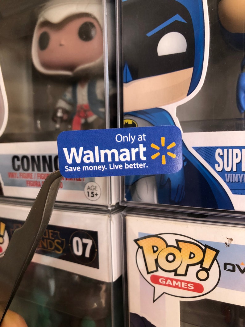 May include: A blue and yellow sticker with the Walmart logo and the text "Only at Walmart Save money. Live better."  The sticker is attached to a clear plastic display case with a blue and black Batman Pop! figure inside.