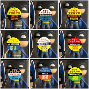 May include: Nine different Batman Pop figures with Toy Tokyo stickers. Each sticker has a different color scheme and indicates the location and year of the convention where the figure was released. The stickers say "Toy Tokyo" and include the location and year of the convention, such as "New York Comic Con 2018" or "San Diego 2019".