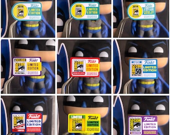 May include: Nine different Funko Pop! figures of Batman, each with a different Comic-Con limited edition sticker. The stickers are yellow, green, blue, red, purple, and black with white text. The stickers feature the Comic-Con logo and the text "Limited Edition".