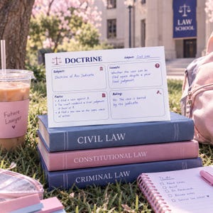 May include: A white study card titled DOCTRINE with sections for Subject, Issue, Facts, and Ruling regarding the Doctrine of Res Judicata, resting on a stack of three hardcover books labelled Civil Law, Constitutional Law, and Criminal Law.