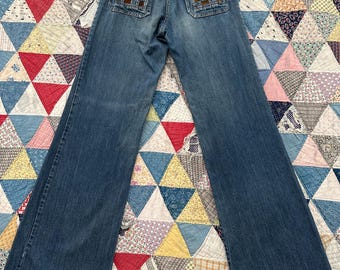 May include: Blue denim jeans with a wide leg and a checkered patch on each back pocket.
