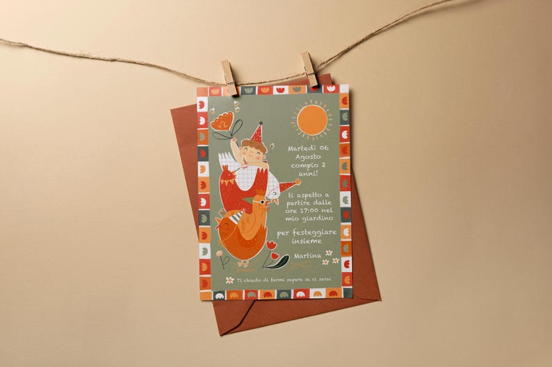 May include: A birthday invitation card with a whimsical illustration of a child riding a bird, with text in Italian. The card is held by a wooden clip on a string, with a brown envelope behind it. The card has a green background and orange accents.
