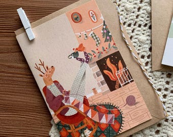 Cozy Reindeer Christmas Card – Knitting by the Fireplace – Holiday Greeting Card with Kraft Envelope