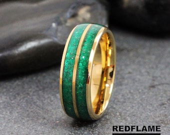 Könnte beinhalten: Ein goldener Wolframcarbid-Ring mit zwei grünen Linien, die in die Band eingelegt sind. Der Ring ist eine beliebte Wahl für Eheringe.