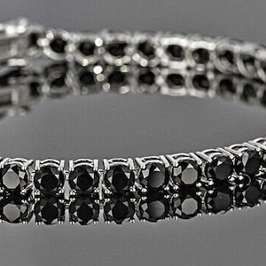 May include: A silver bracelet with a double row of black round stones.
