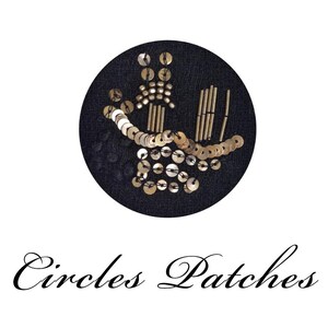 May include: A black circular patch with gold sequins and beads arranged in an abstract design. The patch has the words "Circles Patches" in elegant script below the circle.