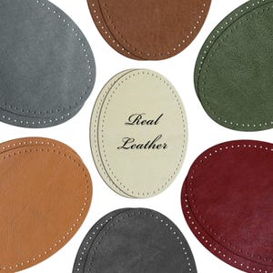 May include: An assortment of oval-shaped leather pieces in various colors, including gray, brown, green, tan, black, orange, and burgundy. Each piece has a stitched border. The central piece reads "Real Leather".