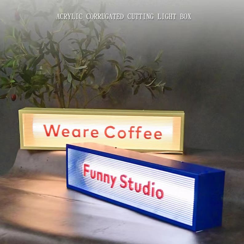 May include: Two acrylic light boxes with corrugated plastic fronts. The top box is light yellow with the text "Weare Coffee" in red. The bottom box is blue with the text "Funny Studio" in red.