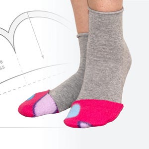 Puede incluir: Un par de calcetines grises hasta el tobillo con dedos de los pies con estampado rosa y azul. Los calcetines están hechos de un material suave y cómodo.