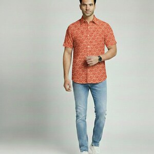 Puede incluir: Una camisa naranja de manga corta con un patr&oacute;n de remolino repetido. Se combina con vaqueros azul claro y zapatillas blancas. Se ve un reloj negro en la mu&ntilde;eca.