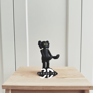 May include: Black and yellow figurine of a cartoon character with the text "3D GADGETRY" on the base.
