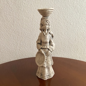 Può includere: Una tazza di ceramica bianca con un manico nero e la scritta "But First, Coffee" in nero, con un carattere a mano. La tazza è su una superficie bianca.