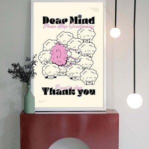 May include: Framed art print with the words "Dear Mind Please Stop Overthinking" and "I need to sleep Thank you." The illustration features a pink brain connected to sheep-like clouds. The print is displayed on a red shelf.