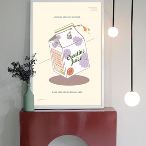 May include: A framed art print featuring a carton of "Creative Juice" with floral accents and a straw. The print includes the text "A complete serving of inspiration" and "A dose a day keeps the blockage away."