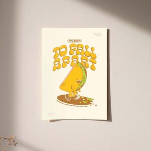 May include: A print featuring a cartoon taco character with a sad expression, standing on a brown oval. The text "IT'S OKAY! TO FALL APART" is above the taco, with "TACOS FALL APART AND WE STILL LOVE THEM" below.