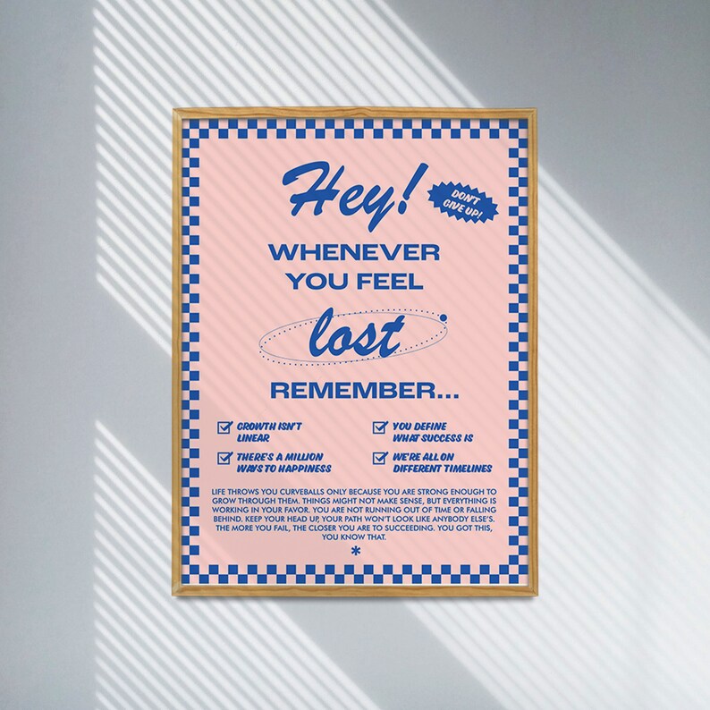 May include: Pink poster with blue text and a checkered border. The poster reads "Hey! Whenever you feel lost, remember..." followed by inspirational statements. A small blue sticker says "Don't Give Up!"