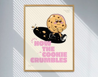 May include: A framed art print featuring a cartoon cookie character holding a smaller cookie. The artwork has a light beige background with the phrase "THAT'S HOW THE COOKIE CRUMBLES" in pink. The cookie character is brown with chocolate chips.